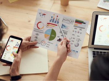 Deux personnes analysant des graphiques et statistiques marketing, illustrant l’évaluation des performances numériques avec Haya Marketing.